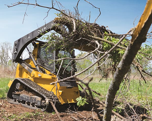 skid steer uprooting a tree stump